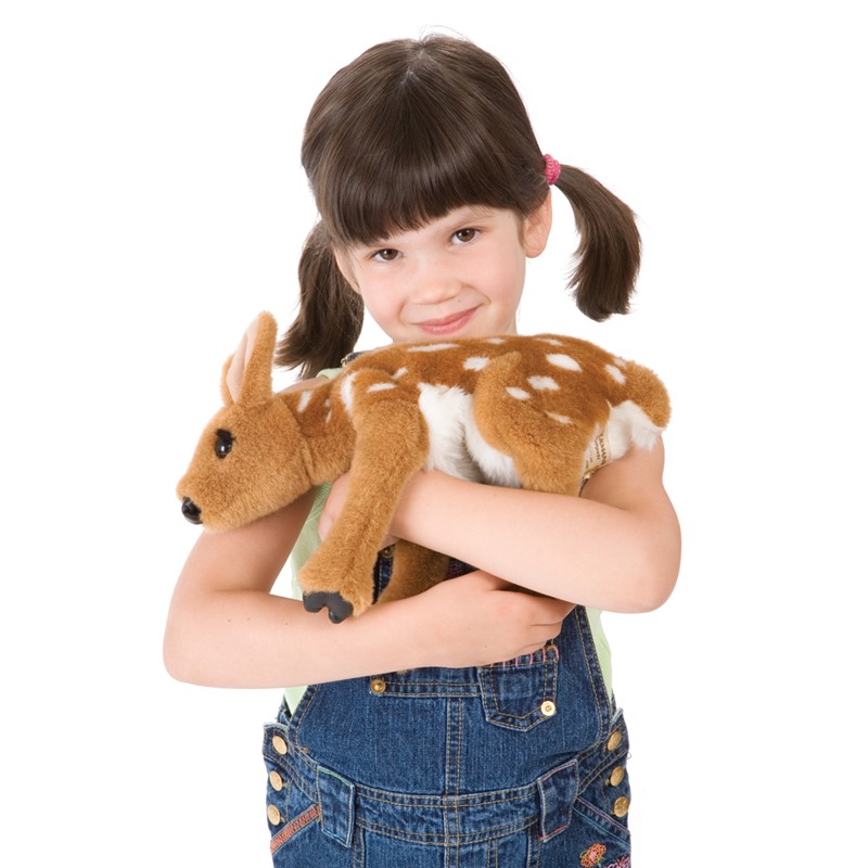 Girl holding the Folkmanis fawn hand puppet with brown fur and white spots in her arms