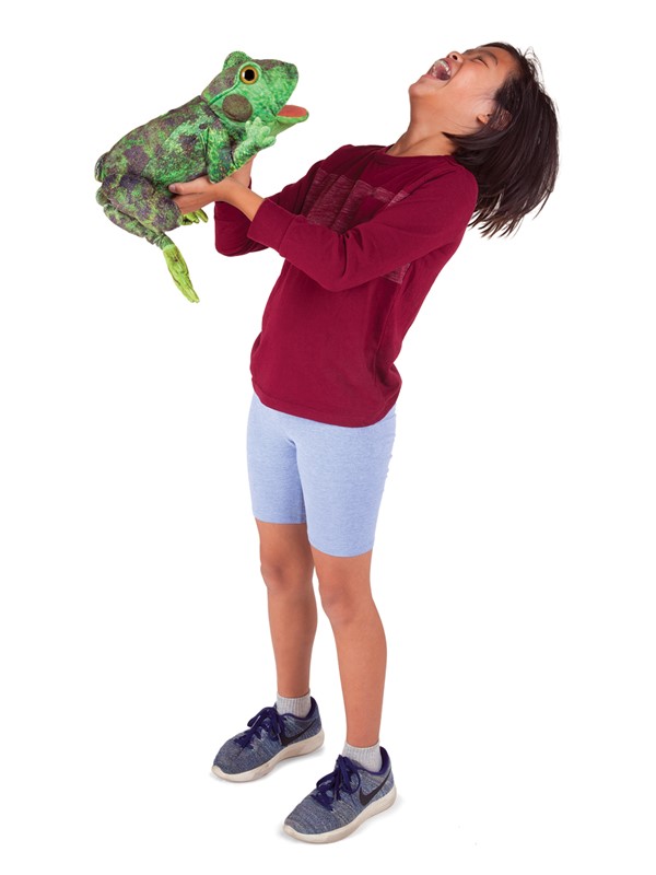 Laughing child holding the Folkmanis green frog metamorphosis hand puppet with its tongue sticking out up in the air