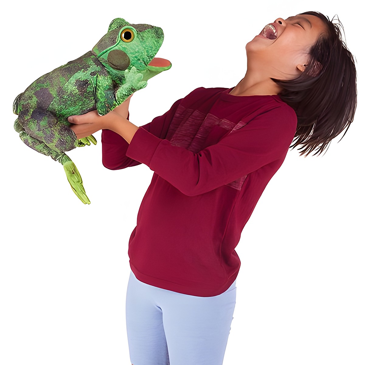 Lachendes Kind hält die Folkmanis Handpuppe Metamorphose Frosch in Grün mit herausgestreckter Zunge in die Höhe.