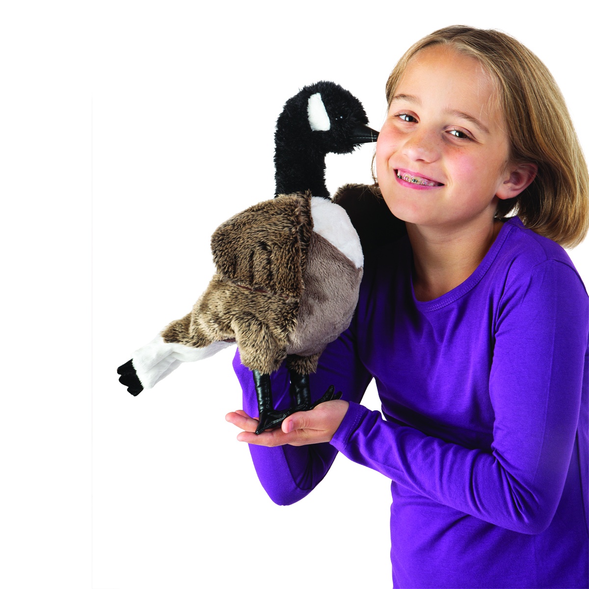 Girl holding up a Folkmanis Canada Goose hand puppet with a black head, white cheek patch, and brown plumage