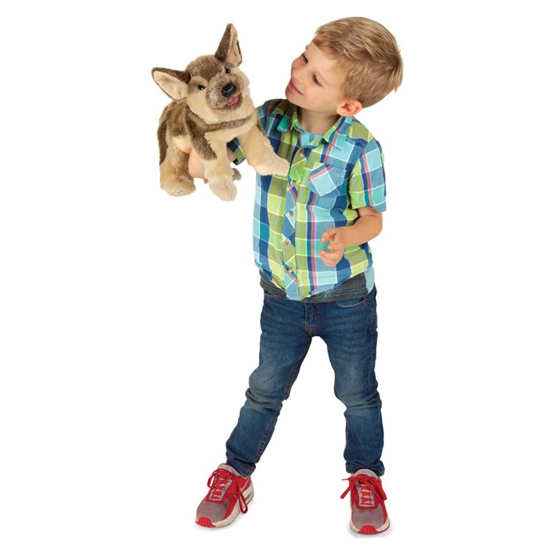 Junge hält Folkmanis Handpuppe Schäferhundwelpe mit braunem Fell und herausgestreckter Zunge in die Höhe