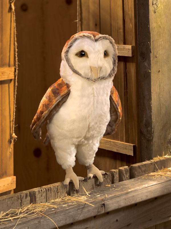 Folkmanis Handpuppe Schleiereule mit weißem Bauchgefieder und rostbraunen Flügeln, stehend auf einem Holzbalken in einer Scheune
