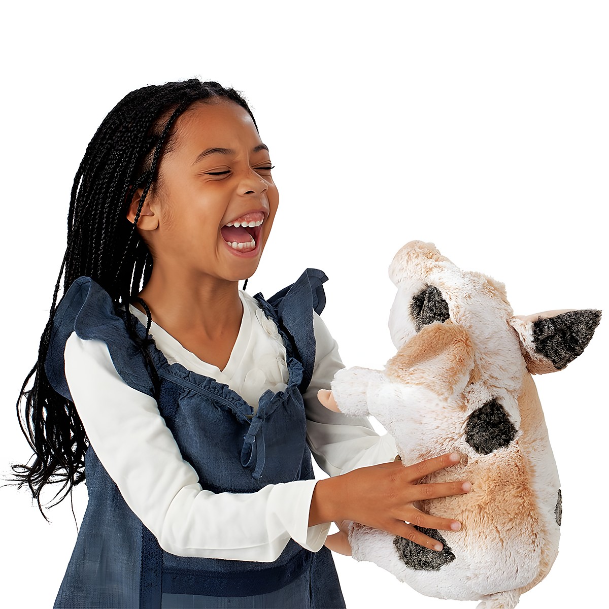 Lachendes Mädchen hält die Folkmanis Handpuppe grunzendes Schweinchen mit beigem Fell und dunklen Flecken in den Händen.