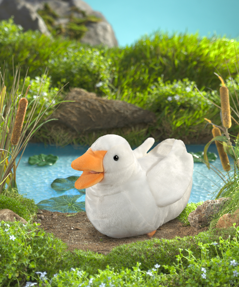 Folkmanis Handpuppe Ente in Weiß mit orangefarbenem Schnabel, sitzend vor einem Teich mit Seerosen und Schilf