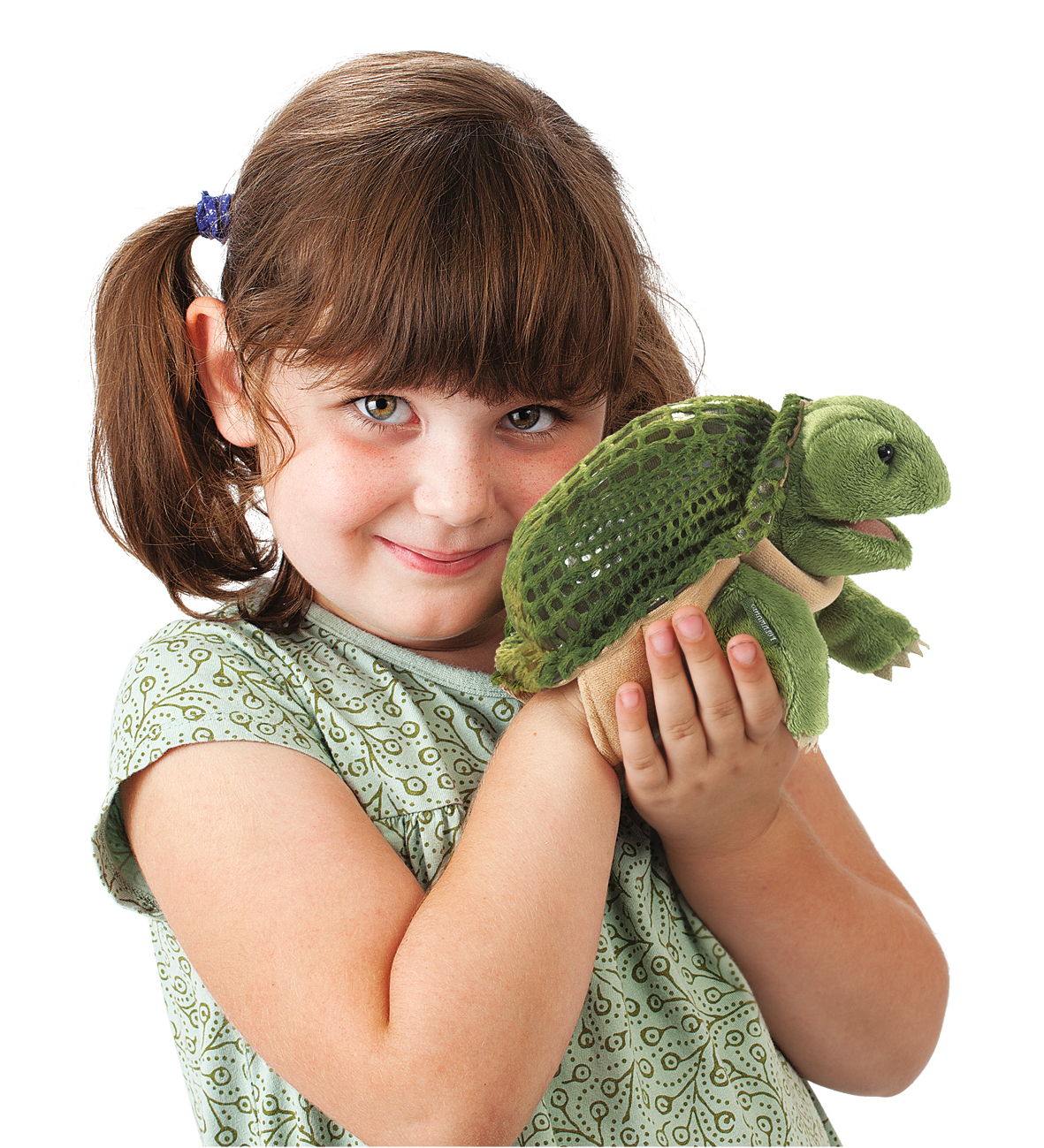 Mädchen hält Folkmanis Handpuppe kleine Schildkröte mit grünem Panzer und Plüschkopf in beiden Händen
