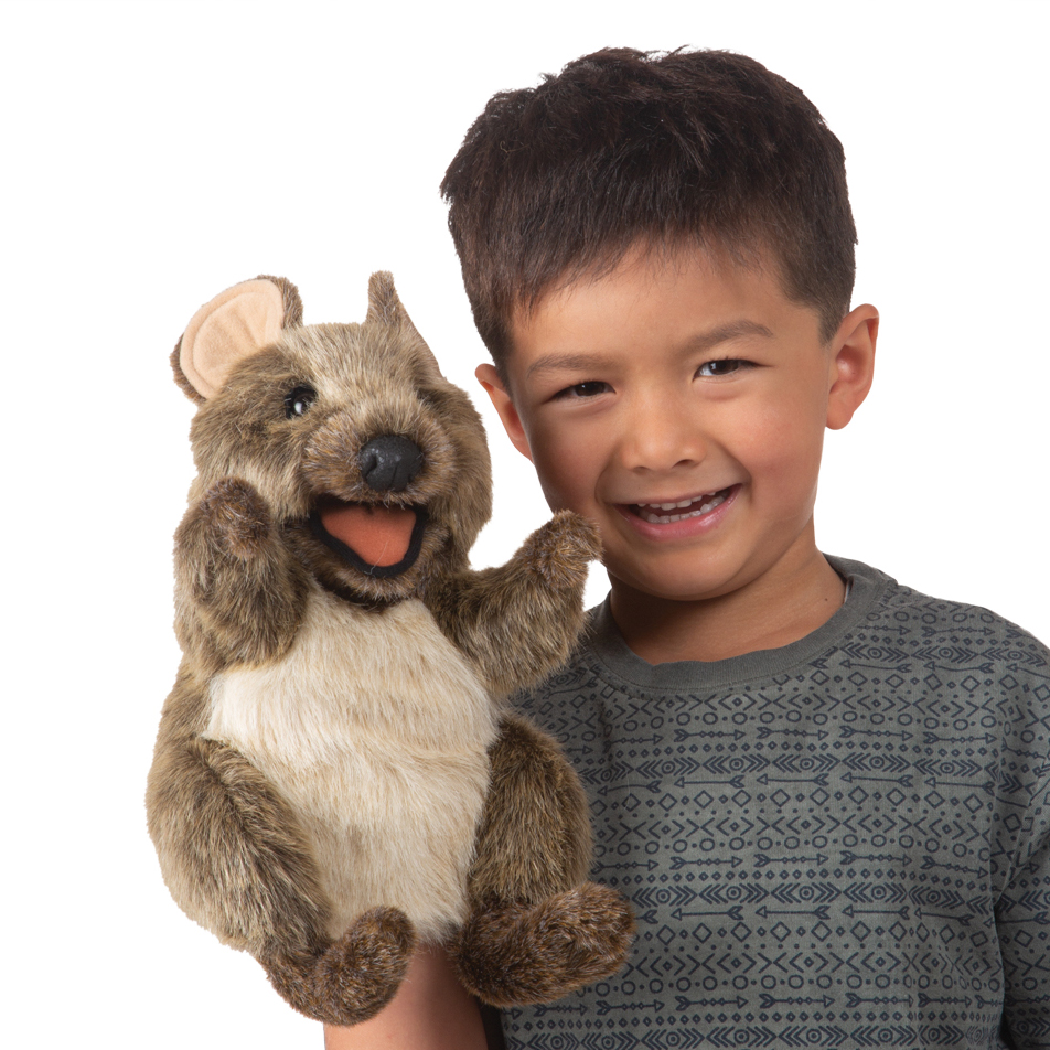 Lachender Junge hält Folkmanis Handpuppe Kurzschwanzkänguru mit geöffnetem Maul und braunem Plüschfell in die Höhe.