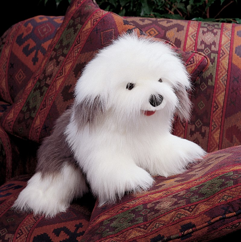 Folkmanis Old English Sheepdog hand puppet with fluffy white and grey fur, seated on a patterned sofa