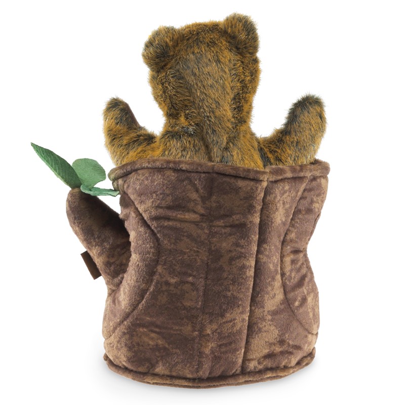 Folkmanis Handpuppe Bär im Baumstumpf, Rückansicht: braun-goldenes Bärenjunges lugt aus einem Plüsch-Baumstumpf mit grünem Blatt hervor.