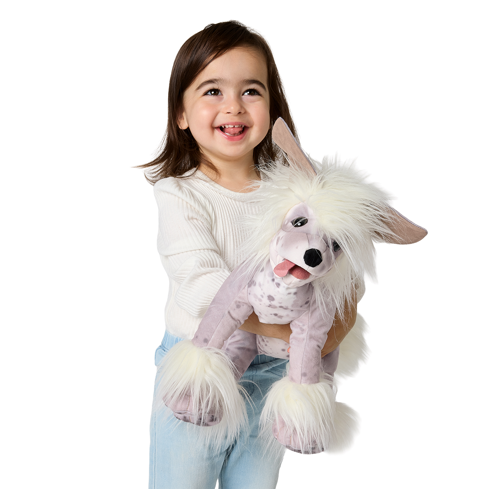 Mädchen hält Folkmanis Handpuppe Chinesischer Schopfhund mit weißem Schopf, gesprenkeltem Fell und herausgestreckter Zunge