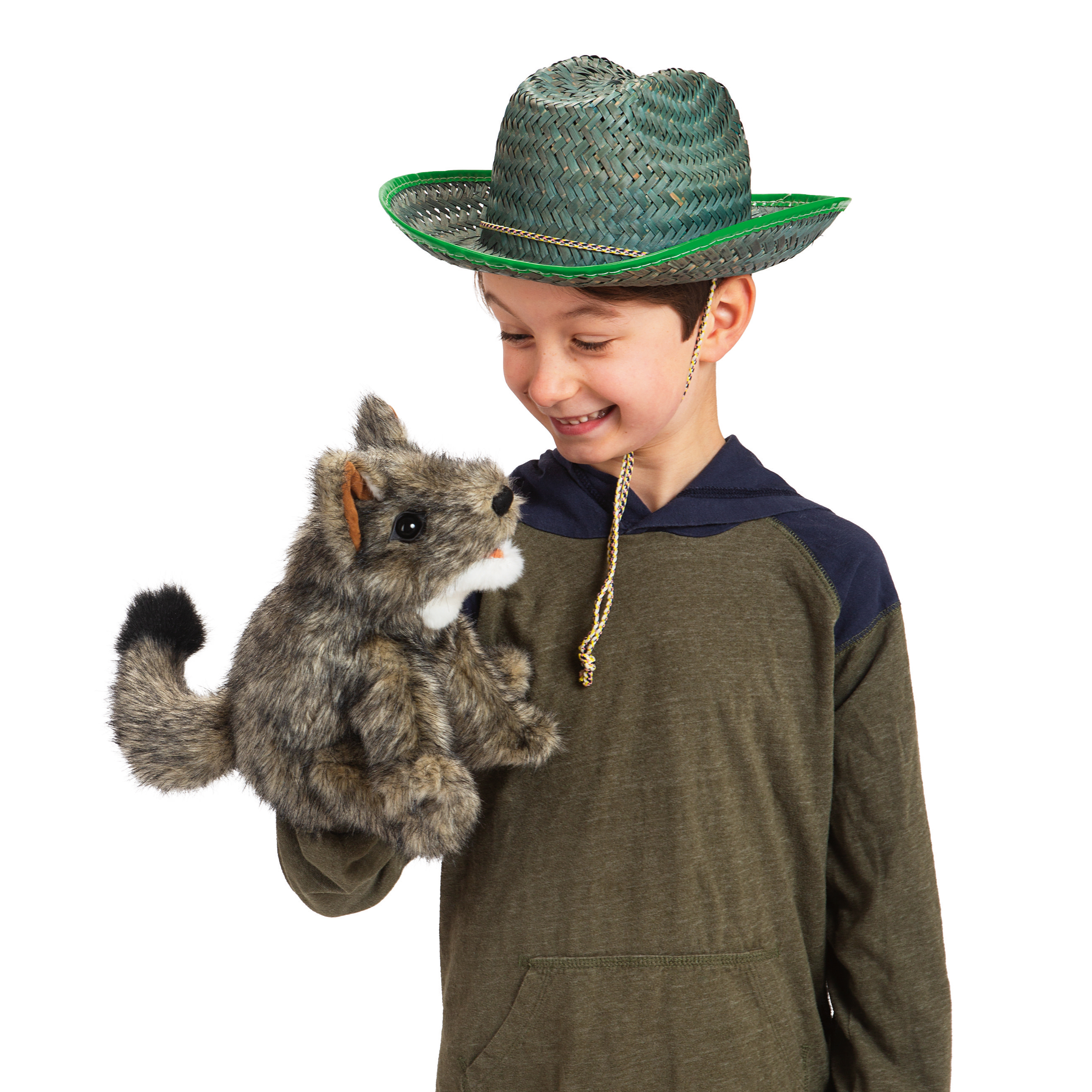 Smiling boy wearing a green straw hat presenting the Folkmanis small coyote hand puppet, grey-brown with a black tail tip, on his hand