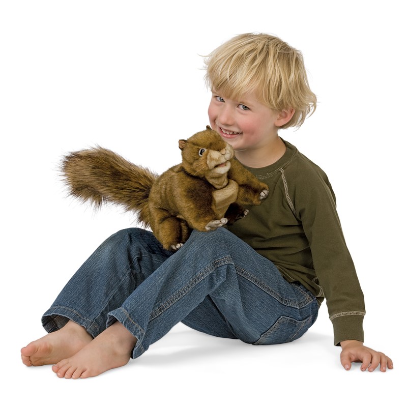Lachender Junge hält Folkmanis Handpuppe rotbraunes Eichhörnchen mit buschigem Schwanz in den Händen