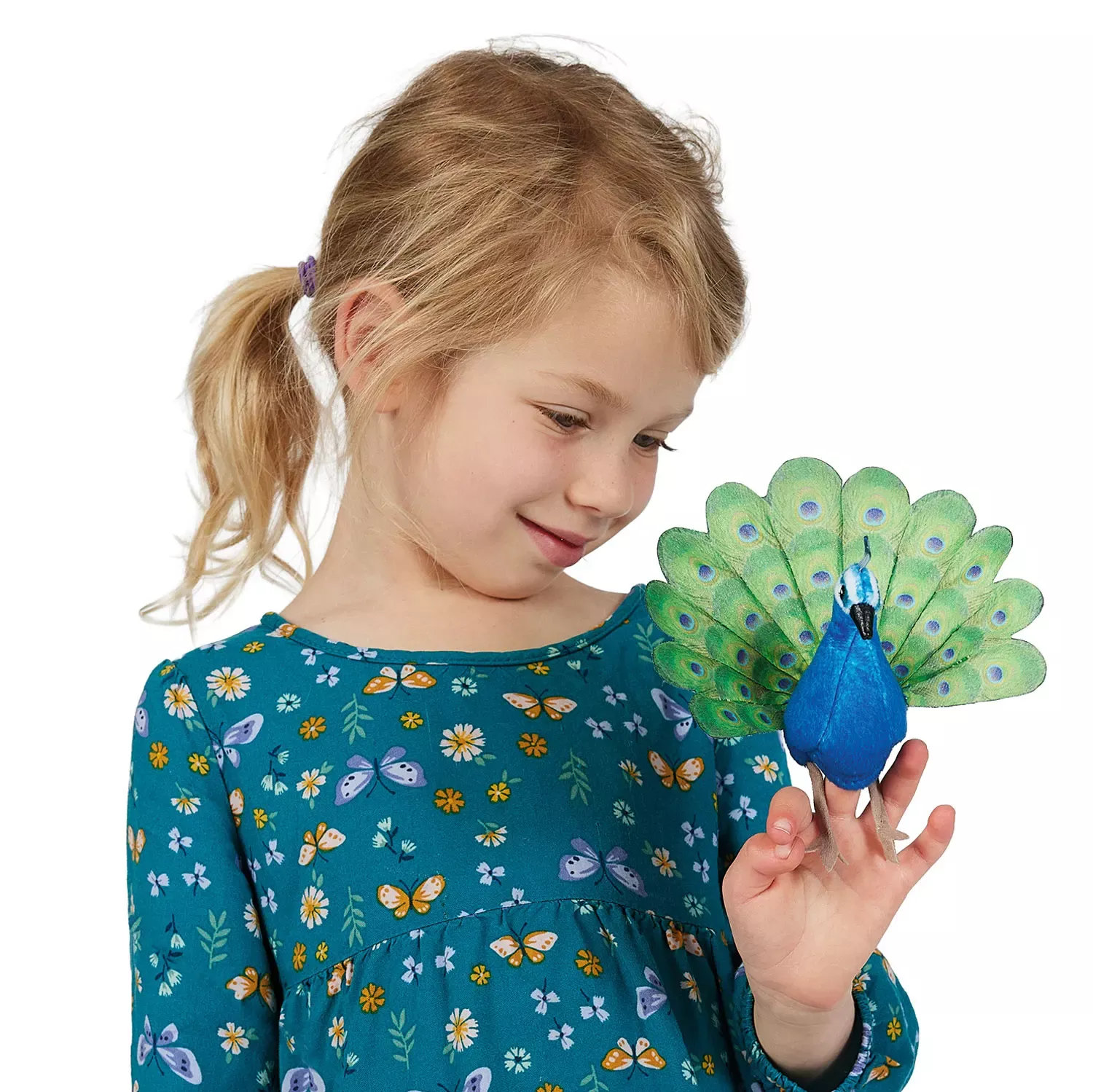 Mädchen trägt Folkmanis Fingerpuppe mini Pfau mit blauem Körper und grün-gemustertem Schweif am Zeigefinger