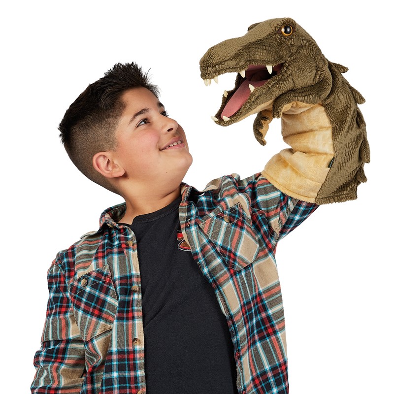Junge hält Folkmanis Krokodil-Handpuppe mit geöffnetem Maul und sichtbaren Zähnen in die Höhe