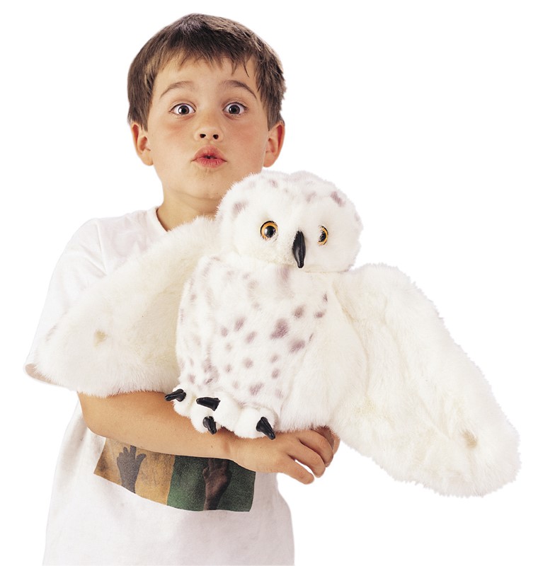 Junge hält Folkmanis Handpuppe Schneeeule mit ausgebreiteten weißen Flügeln, schwarzem Schnabel und gelben Augen in den Armen.