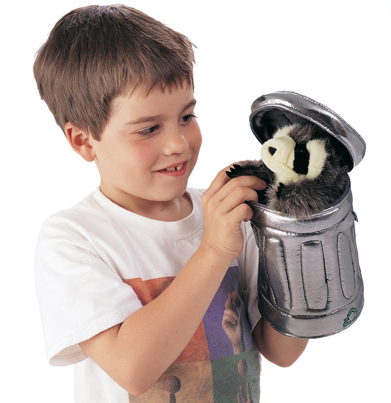 Boy holding the Folkmanis raccoon hand puppet inside a silver fabric garbage can with a flip-open lid