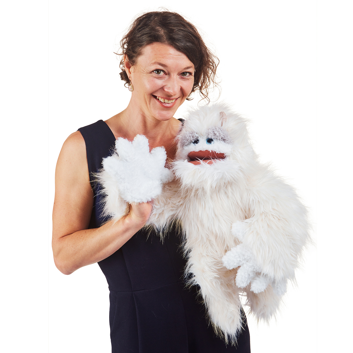 Folkmanis Yeti hand puppet with white long fur and moveable mouth, worn on a woman's hand