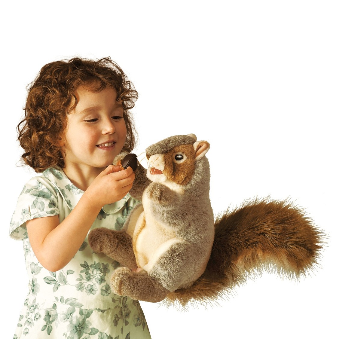 Mädchen hält Folkmanis Handpuppe graues Eichhörnchen mit buschigem Schwanz und hält ihr eine Eichel hin