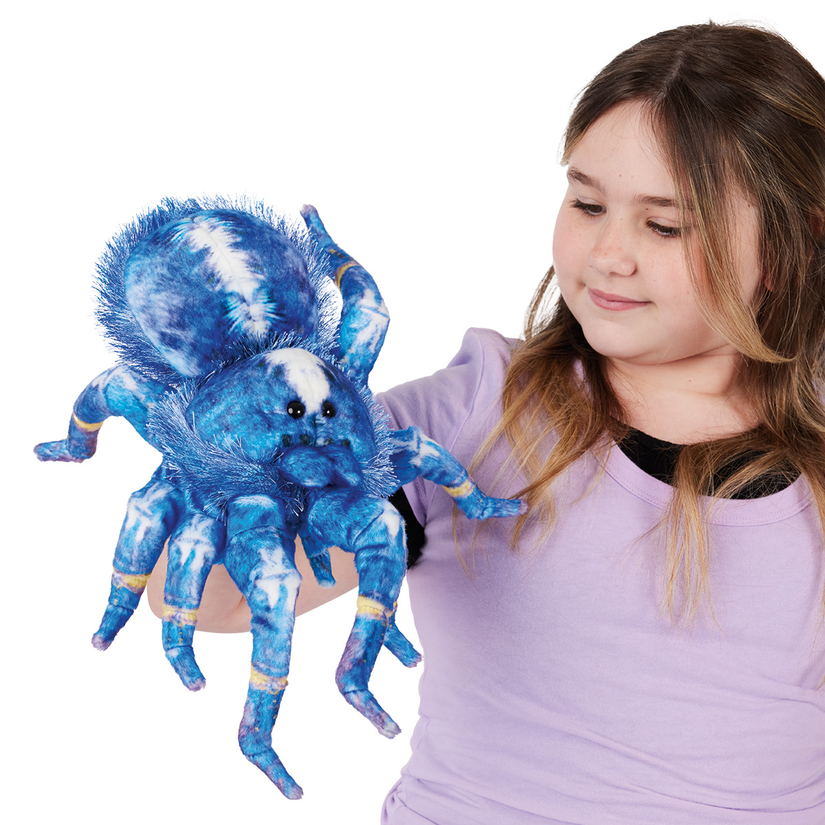 Folkmanis blue and white ornamental tarantula hand puppet on a girl's hand, front view with front legs raised