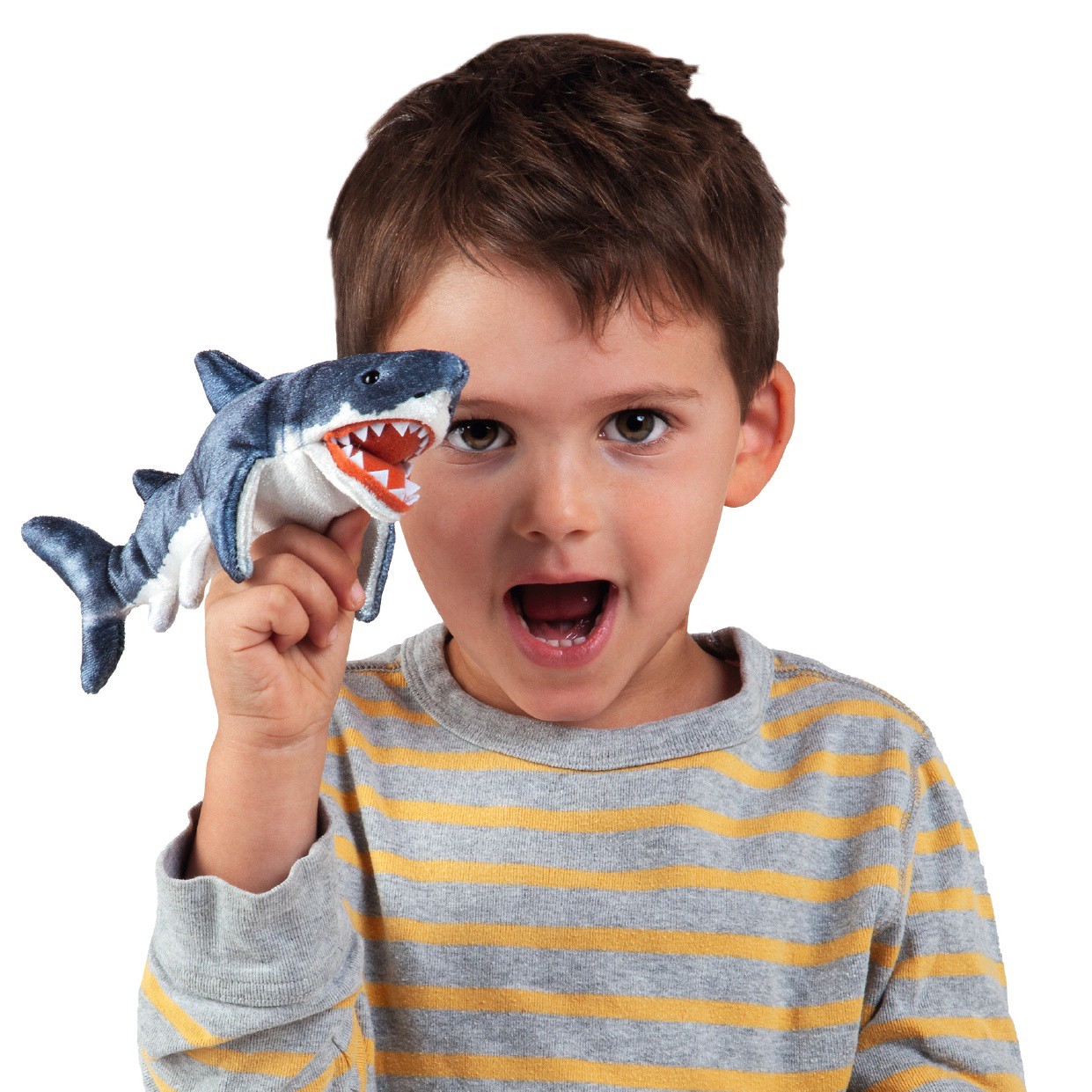 Boy holding a Folkmanis mini shark finger puppet with open mouth and visible teeth on his index finger