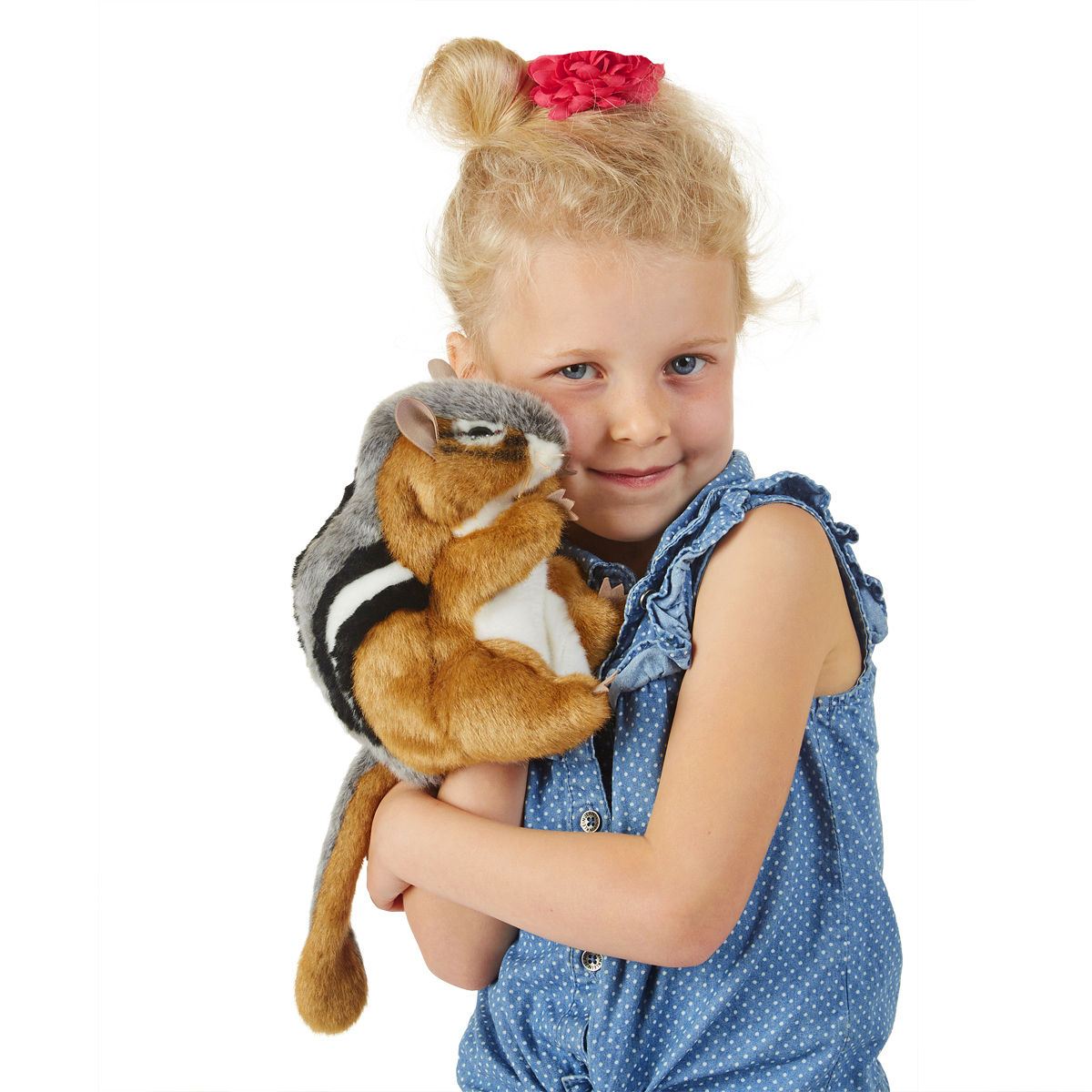 Mädchen hält Folkmanis Handpuppe Streifenhörnchen mit braun-schwarzen Streifen und grauem Rücken an die Wange