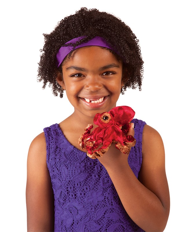 Girl holding a small red Folkmanis Mini Octopus finger puppet with brown tentacles on her hand