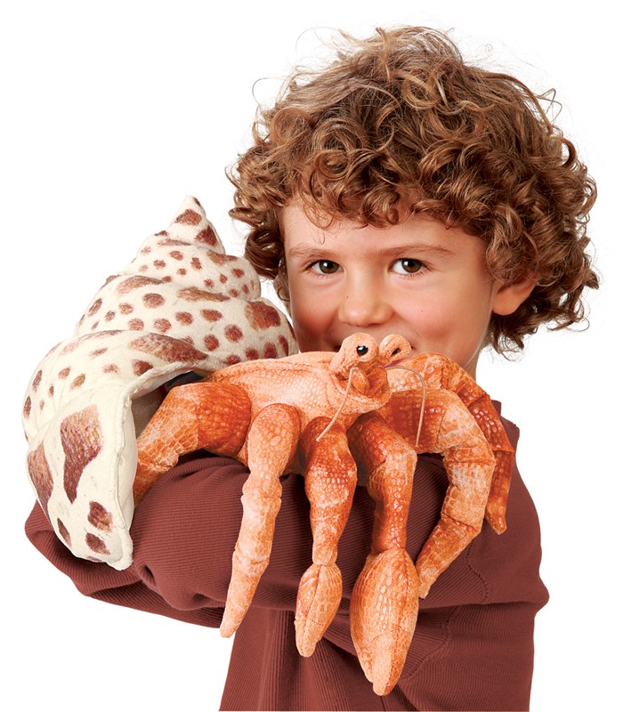 Folkmanis Handpuppe Einsiedlerkrebs in Orange mit geflecktem Schneckenhaus, von einem Kind in die Kamera gehalten