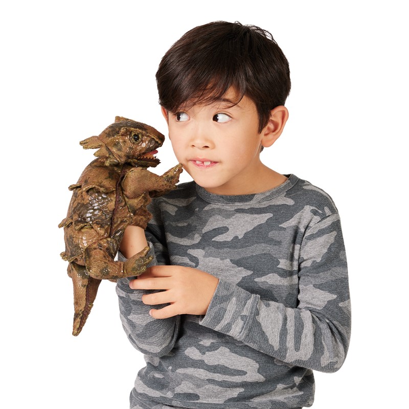 Boy holds the Folkmanis horned lizard hand puppet in brown tones on his shoulder and looks at it sideways