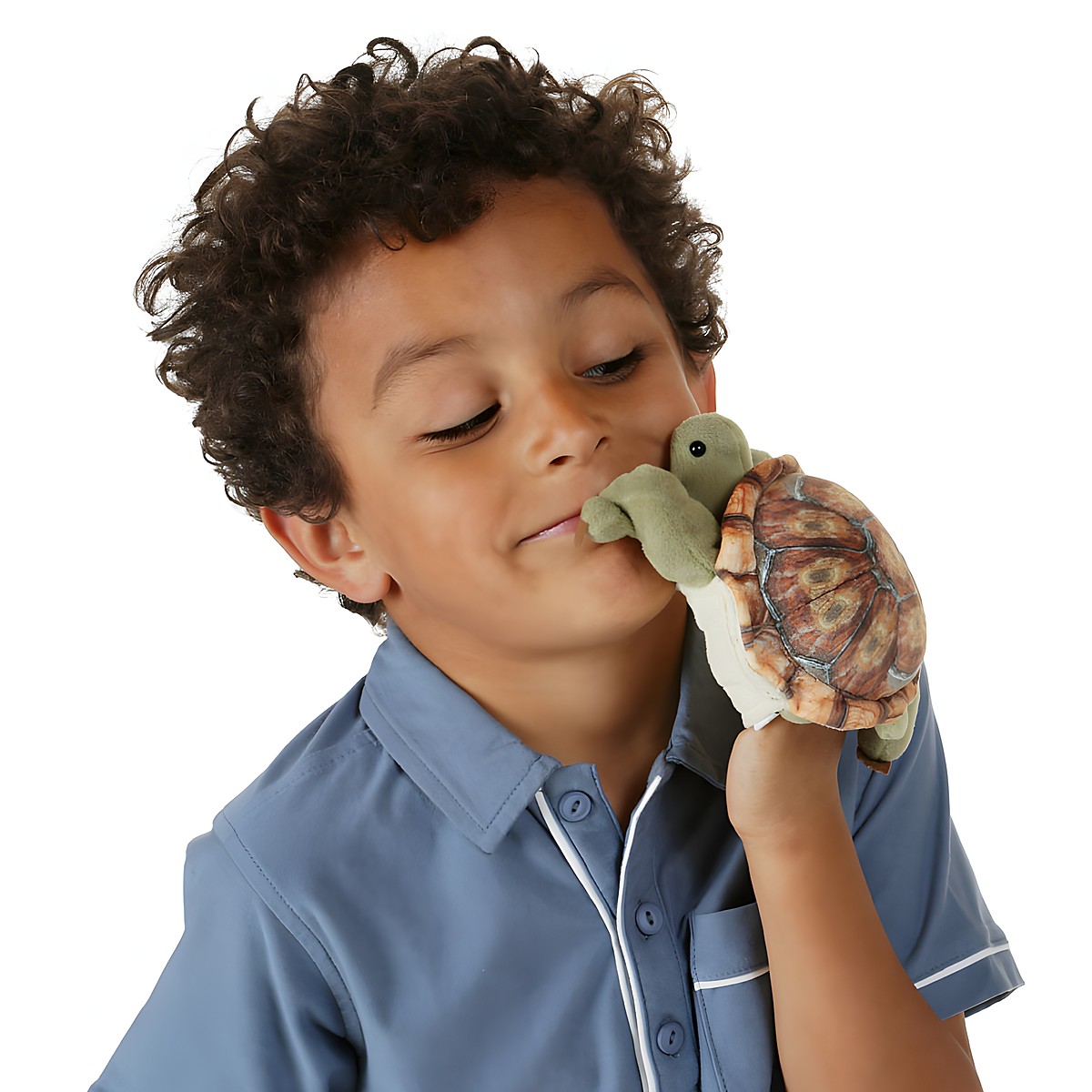 Boy holding a Folkmanis mini tortoise finger puppet with a realistically printed shell up to his face