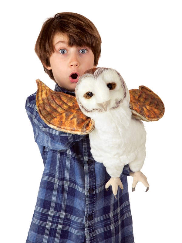 Junge hält Folkmanis Handpuppe Schleiereule mit ausgebreiteten Flügeln und weißem Gefieder in die Kamera