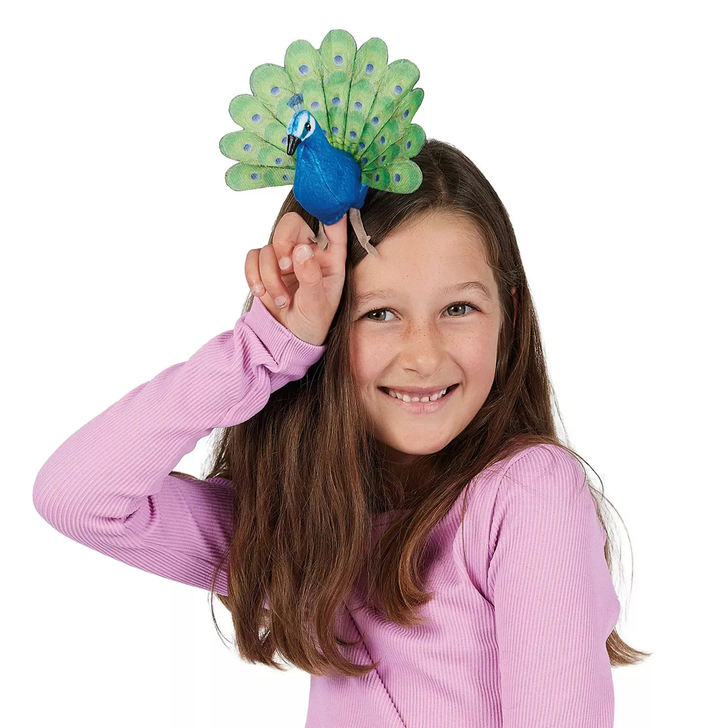 Mädchen hält Folkmanis Fingerpuppe mini Pfau mit blauem Körper und grünem Rad auf dem Zeigefinger über den Kopf.