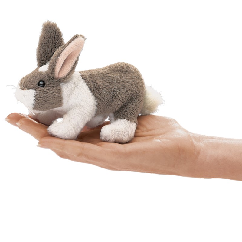 Folkmanis mini rabbit finger puppet in grey and white lying on an open palm, side view