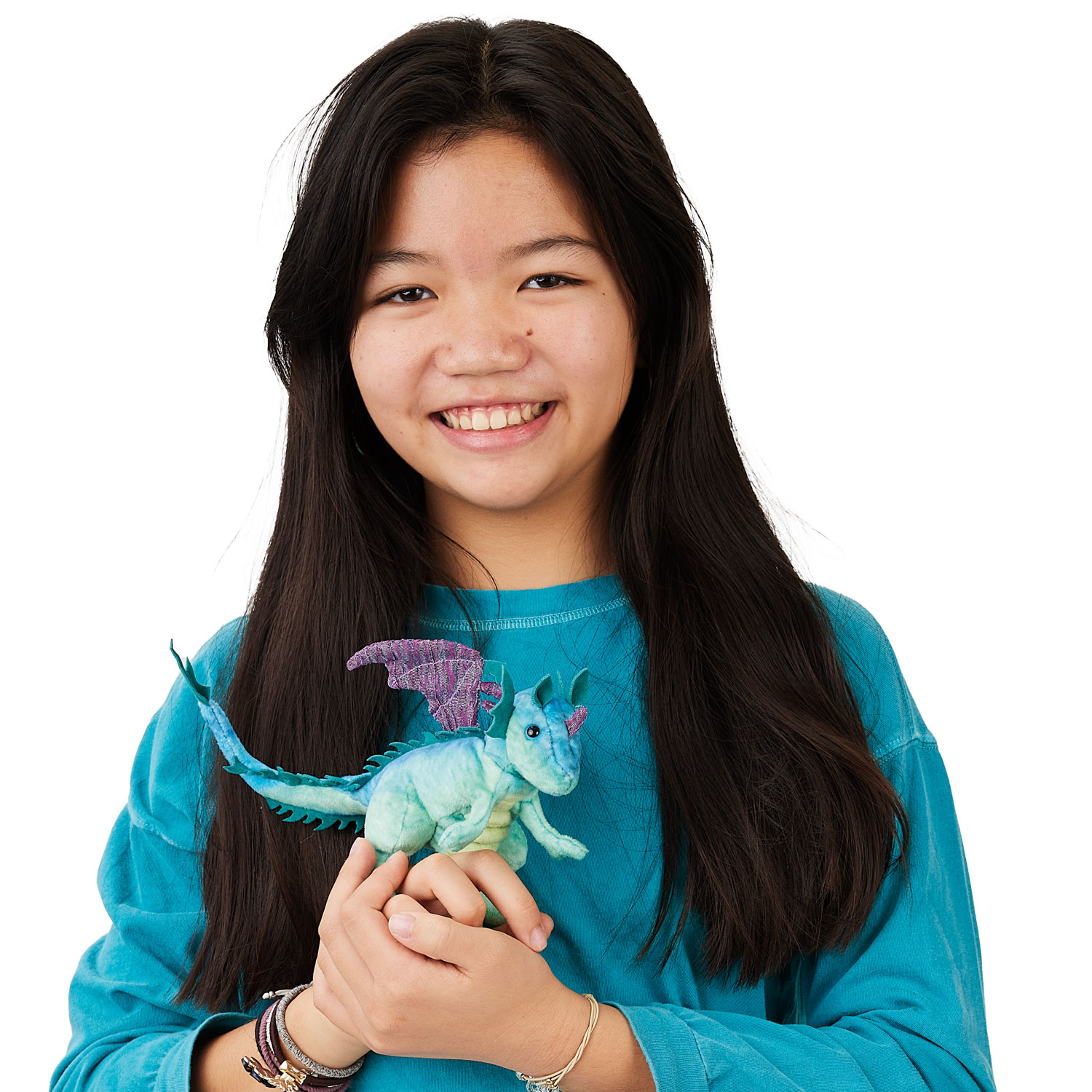 Mädchen hält Folkmanis Fingerpuppe mini Drache in Mintgrün mit lila Flügeln in beiden Händen vor weißem Hintergrund.