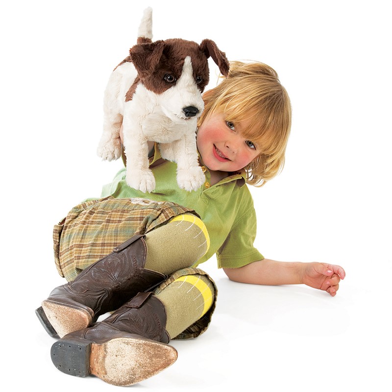 Folkmanis Jack Russell Terrier hand puppet in white and brown sitting on the shoulder of a smiling child, side view