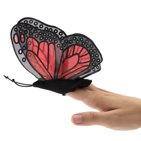 Folkmanis Fingerpuppe mini Monarchschmetterling mit rot-schwarzen Flügeln auf einem Zeigefinger, Seitenansicht
