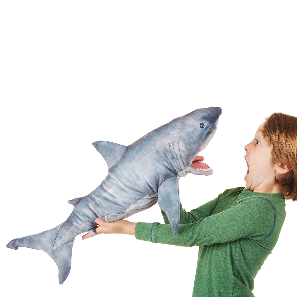 Junge hält Folkmanis Handpuppe Großer Weißer Hai mit geöffnetem Maul auf sich zu, grau-weißes Plüsch, Seitenansicht