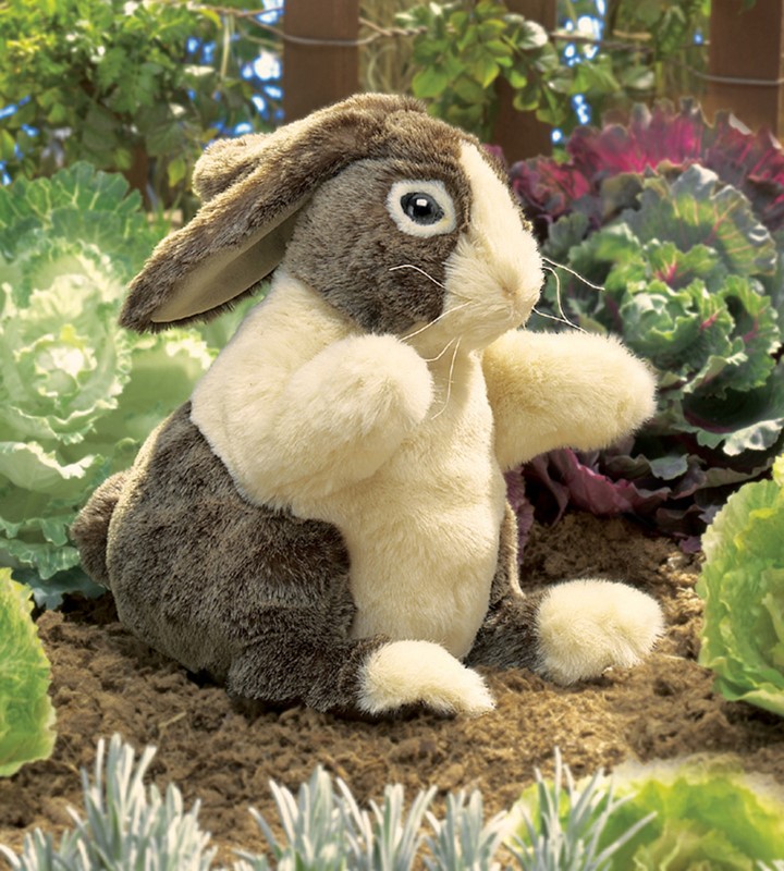 Folkmanis Handpuppe Hase Holländer mit braunem Fell und weißer Brust, aufgerichtet sitzend im Gemüsegarten