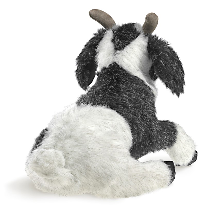 Folkmanis goat hand puppet in black and white, lying down seen from behind, with grey-brown horns and shaggy fur