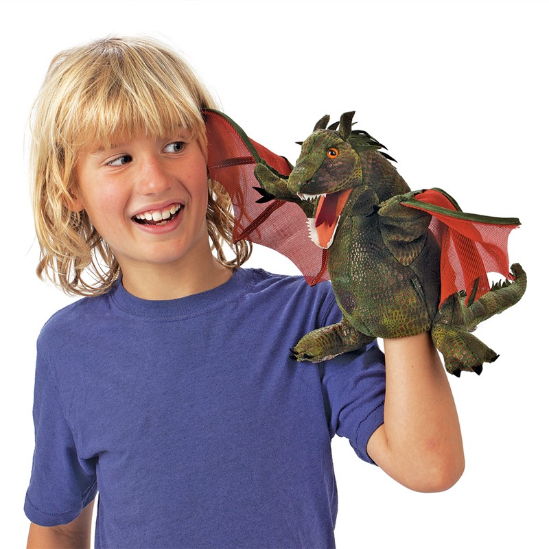 Boy holding a green Folkmanis dragon hand puppet with red wings and an open mouth on his hand