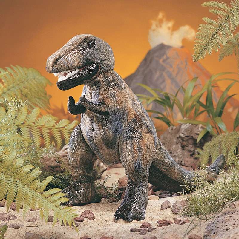 Folkmanis hand puppet small Tyrannosaurus Rex with open jaws and detailed scale texture, posed in front of a prehistoric backdrop with volcano