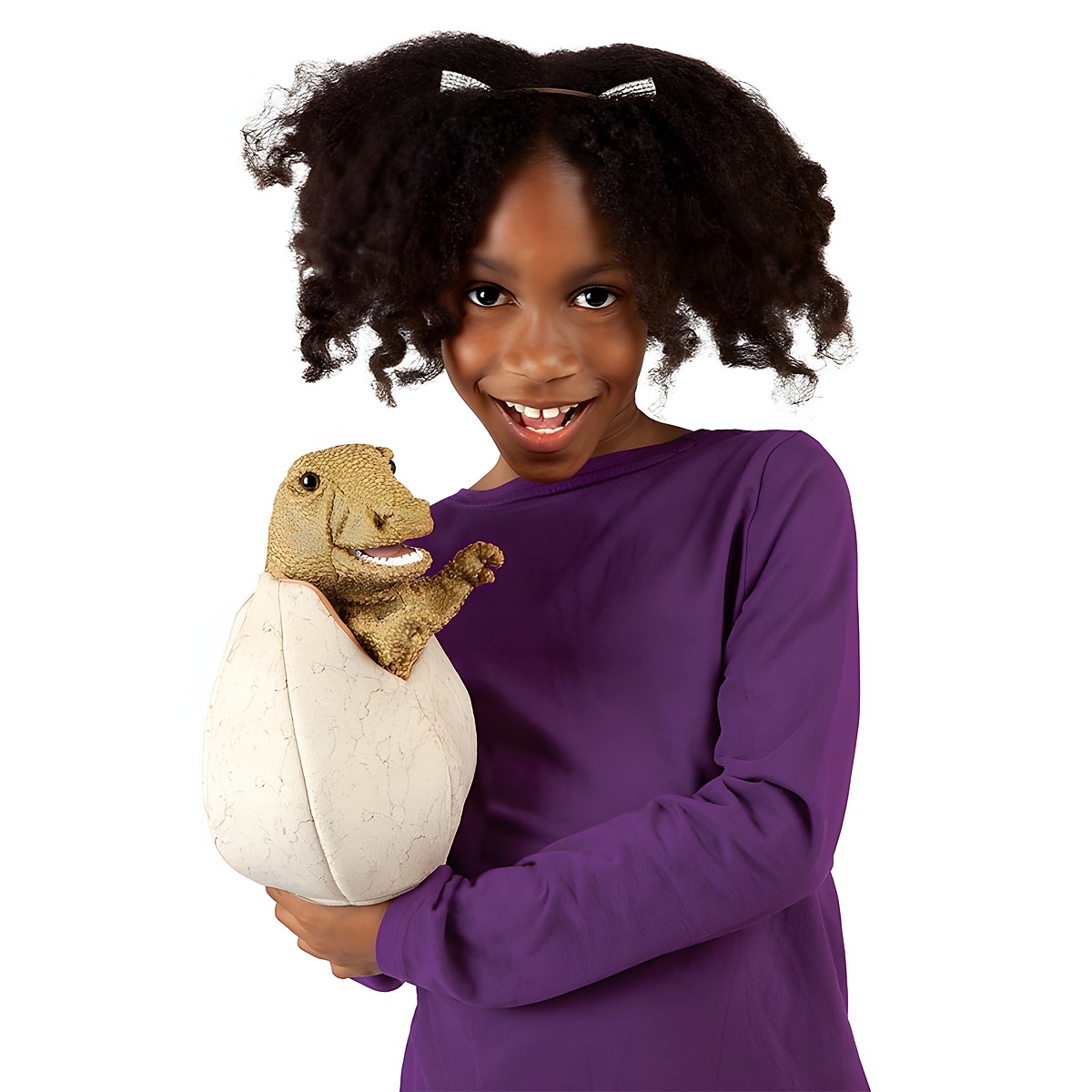 Girl holding the Folkmanis hand puppet baby dinosaur in egg, brown-green dinosaur peeking out of a cream-coloured egg