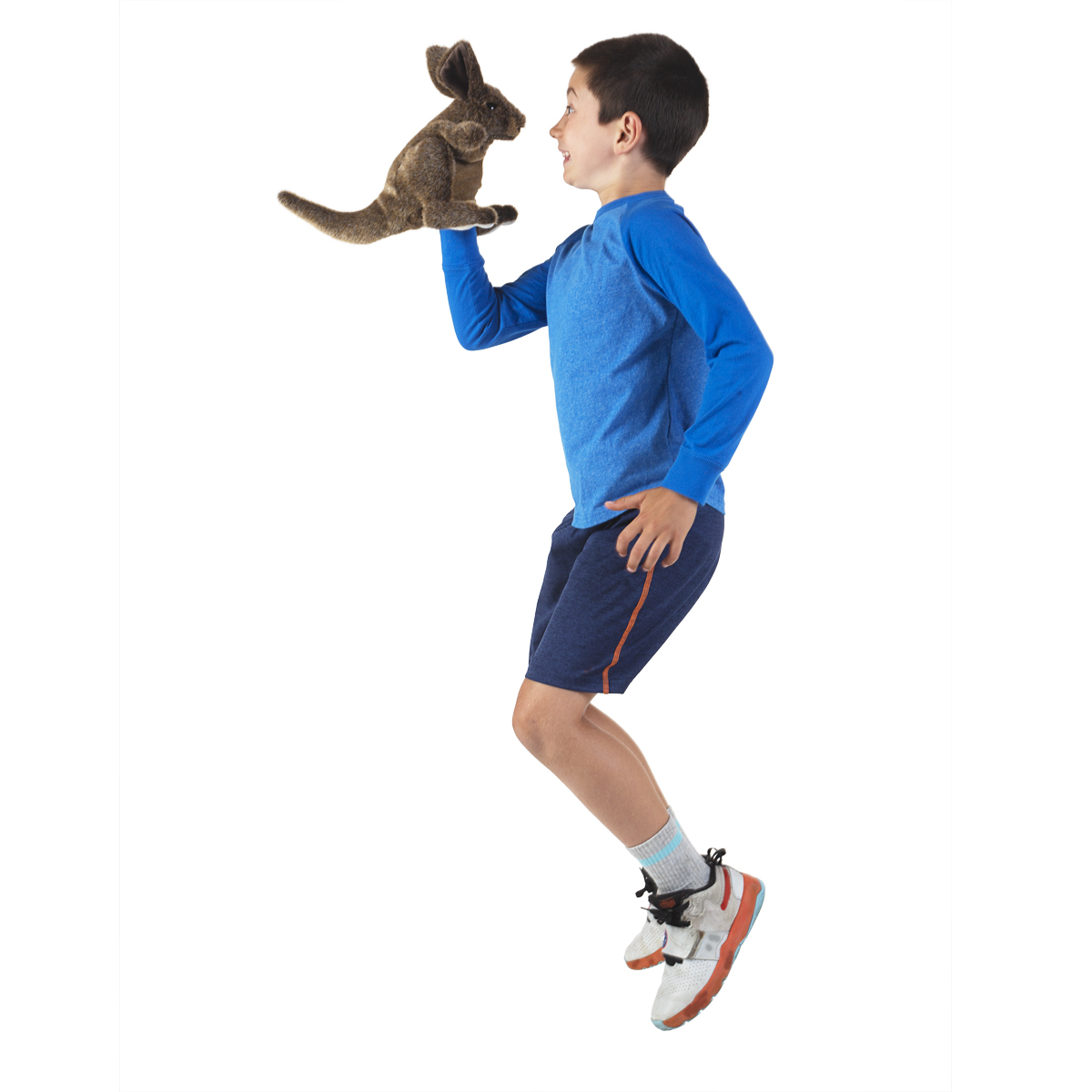 Junge springt in die Luft und führt die braune Folkmanis Handpuppe kleines Känguru auf seiner ausgestreckten Hand