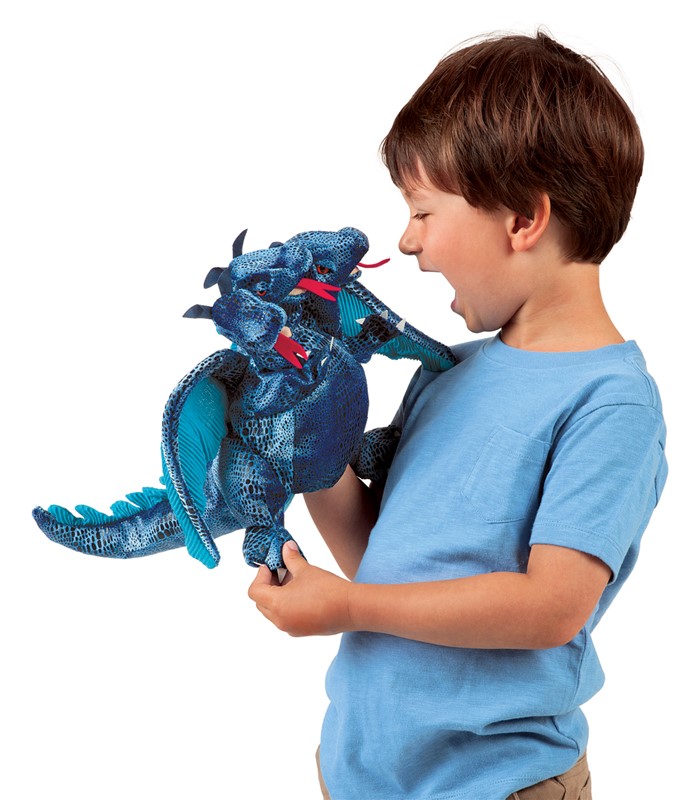 Boy playing with a blue three-headed dragon hand puppet by Folkmanis, side view with open mouths and red tongues