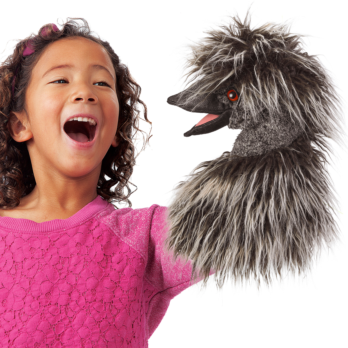 Lächelndes Mädchen hält Folkmanis Emu-Handpuppe mit grau-zotteligen Federn und geöffnetem Schnabel über den ausgestreckten Arm.
