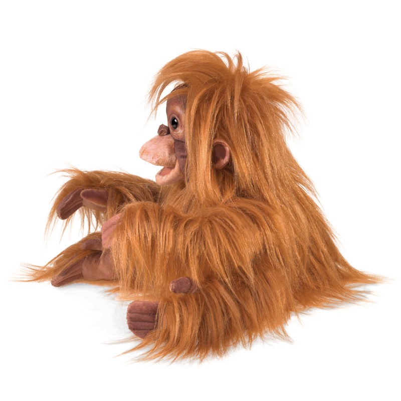 Folkmanis baby orangutan hand puppet with shaggy reddish-brown fur and a detailed face, shown from a side angle