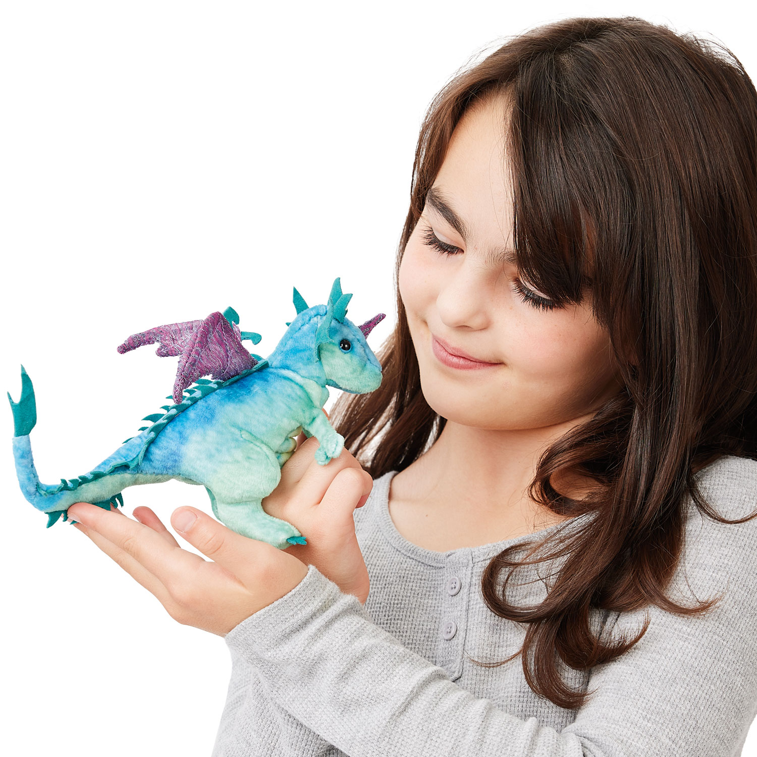 Mädchen hält Folkmanis Fingerpuppe mini Drache in Blau-Grün mit lila Flügeln auf der Handfläche