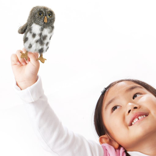 Folkmanis Fingerpuppe mini Fleckenkauz grau-weiß gefleckt auf dem Zeigefinger eines lächelnden Mädchens
