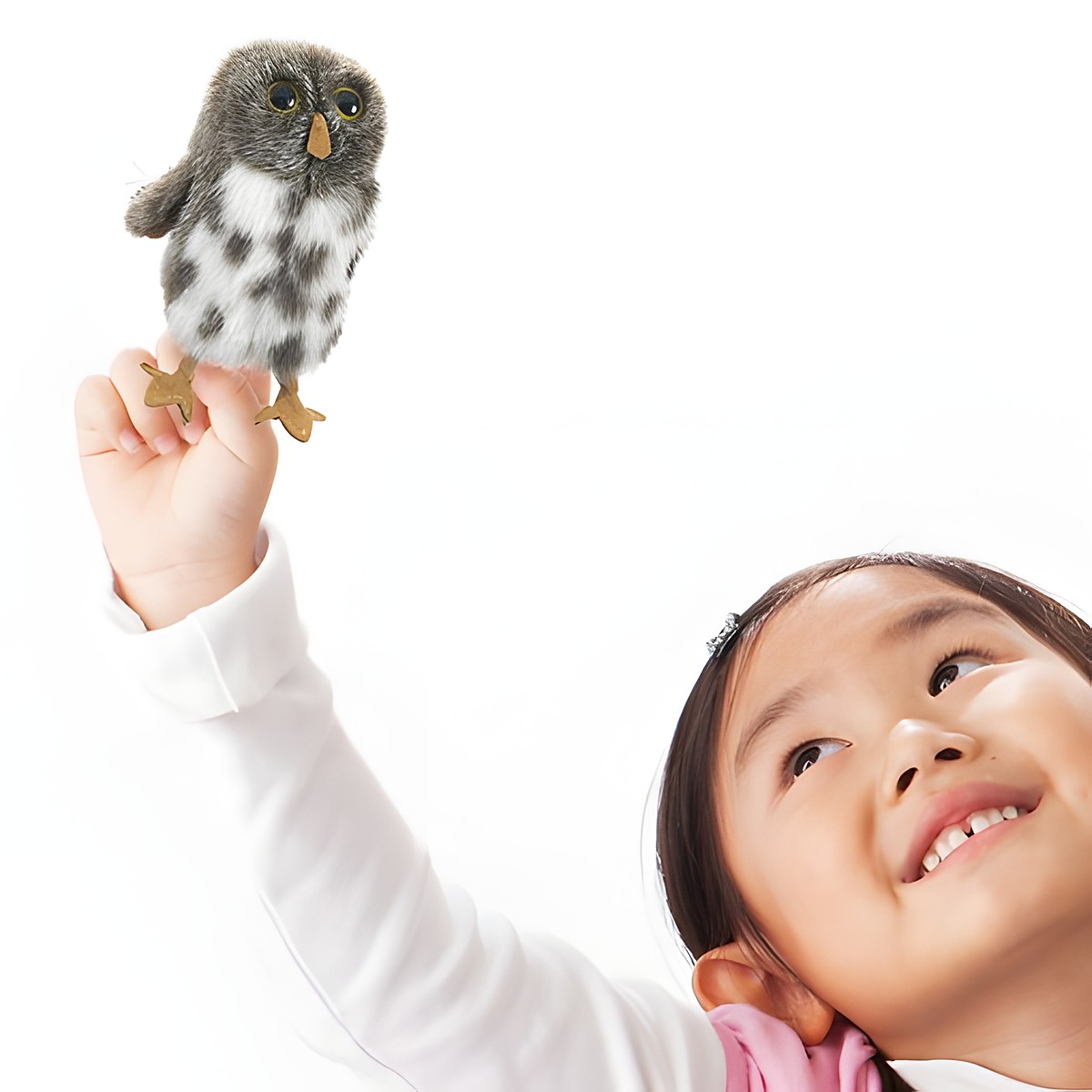 Folkmanis Fingerpuppe mini Fleckenkauz grau-weiß gefleckt auf dem Zeigefinger eines lächelnden Mädchens