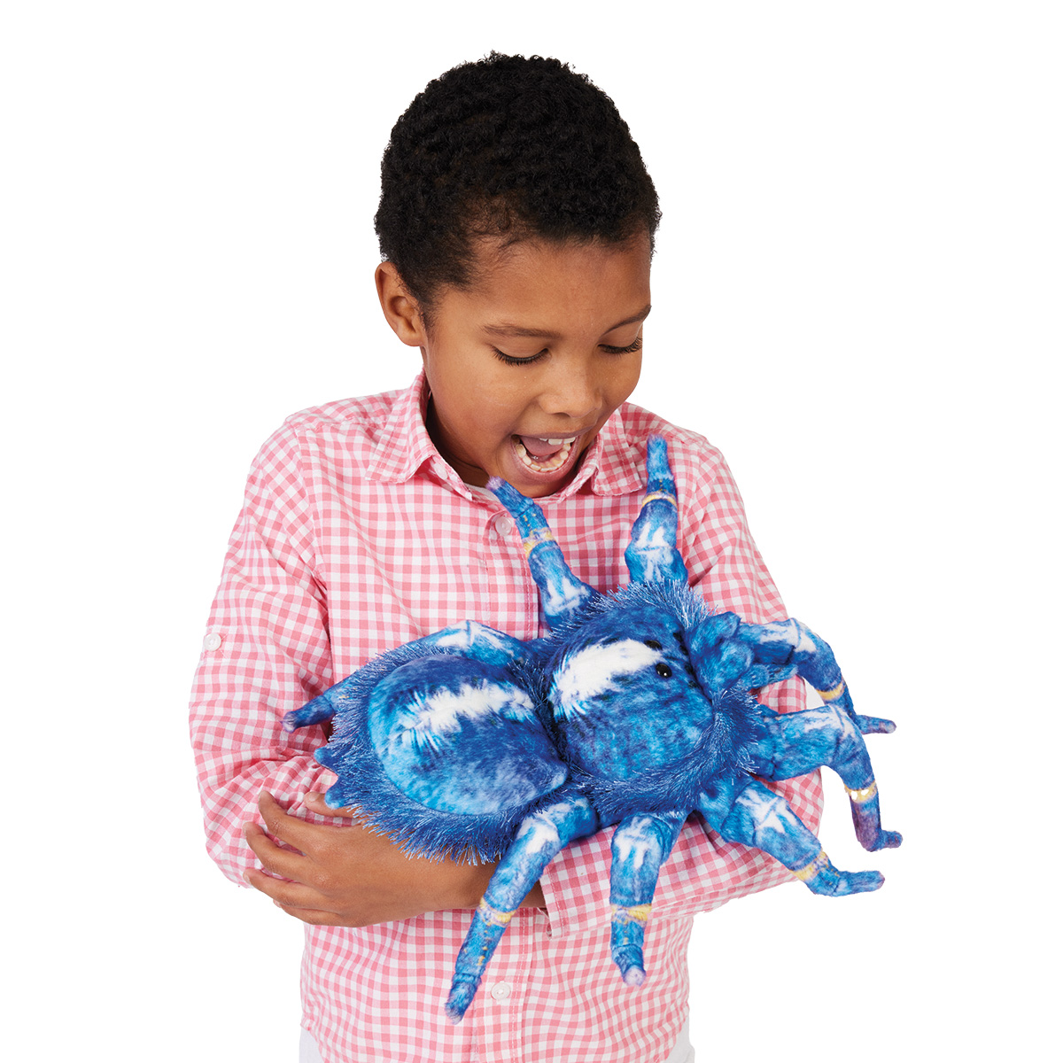 Child laughing while holding the Folkmanis blue tarantula hand puppet with a blue-and-white plush body and eight legs in both hands