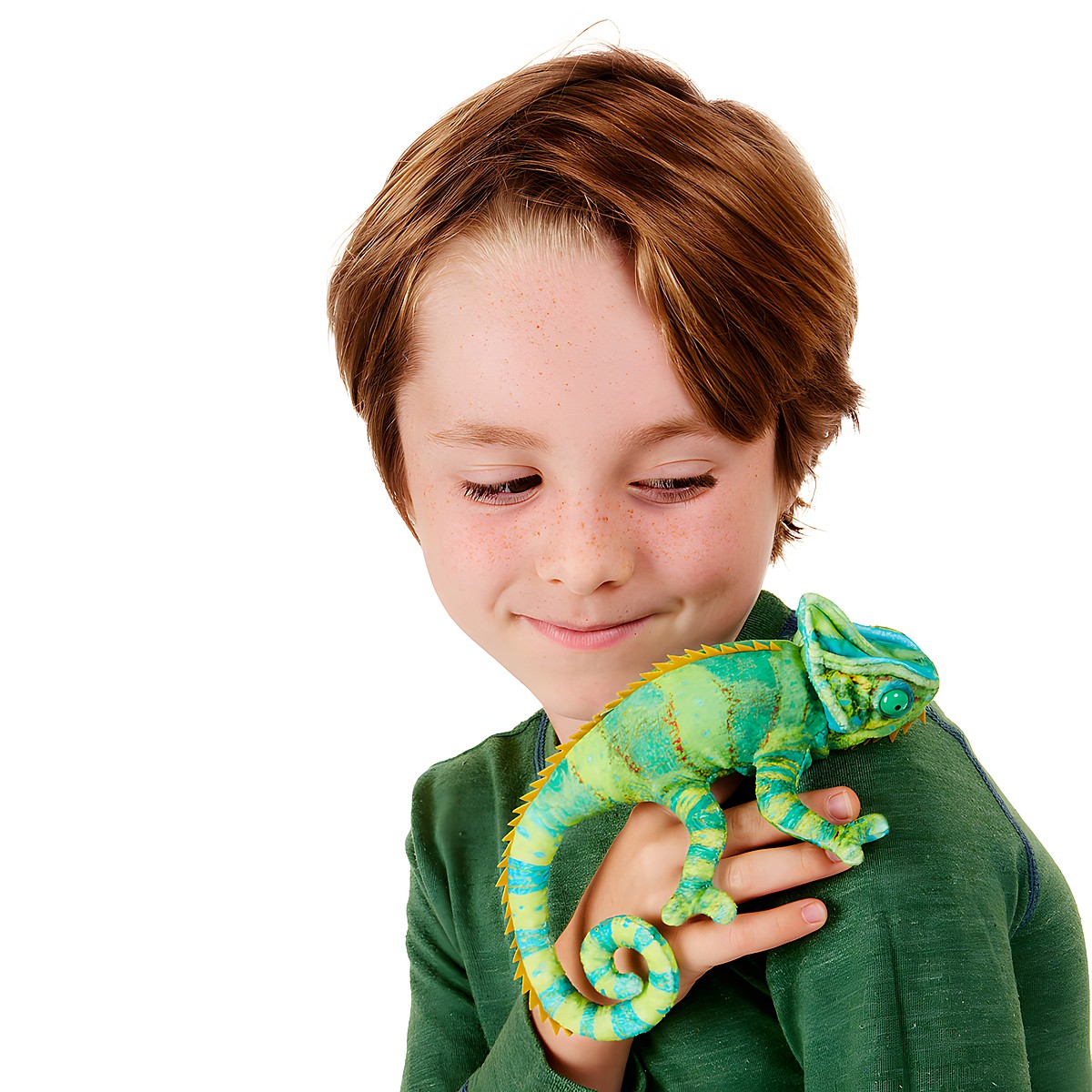Boy holding a Folkmanis mini chameleon finger puppet in green and blue tones on his hand, smiling down at it