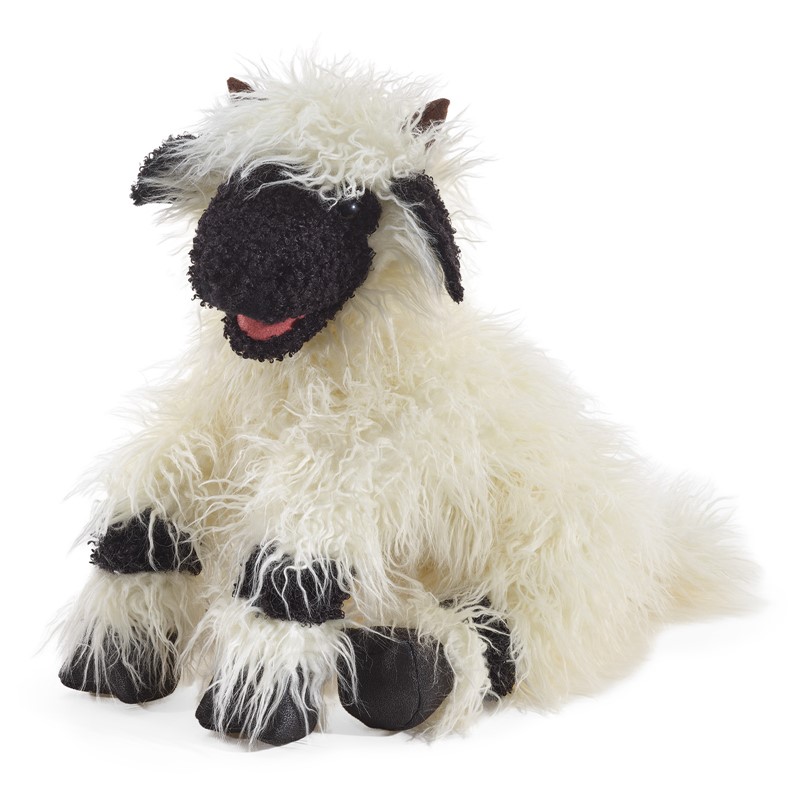 Folkmanis Handpuppe Walliser Schwarznasenschaf mit schwarzem Gesicht, langem cremefarbenen Fell und beweglichem Maul, liegend